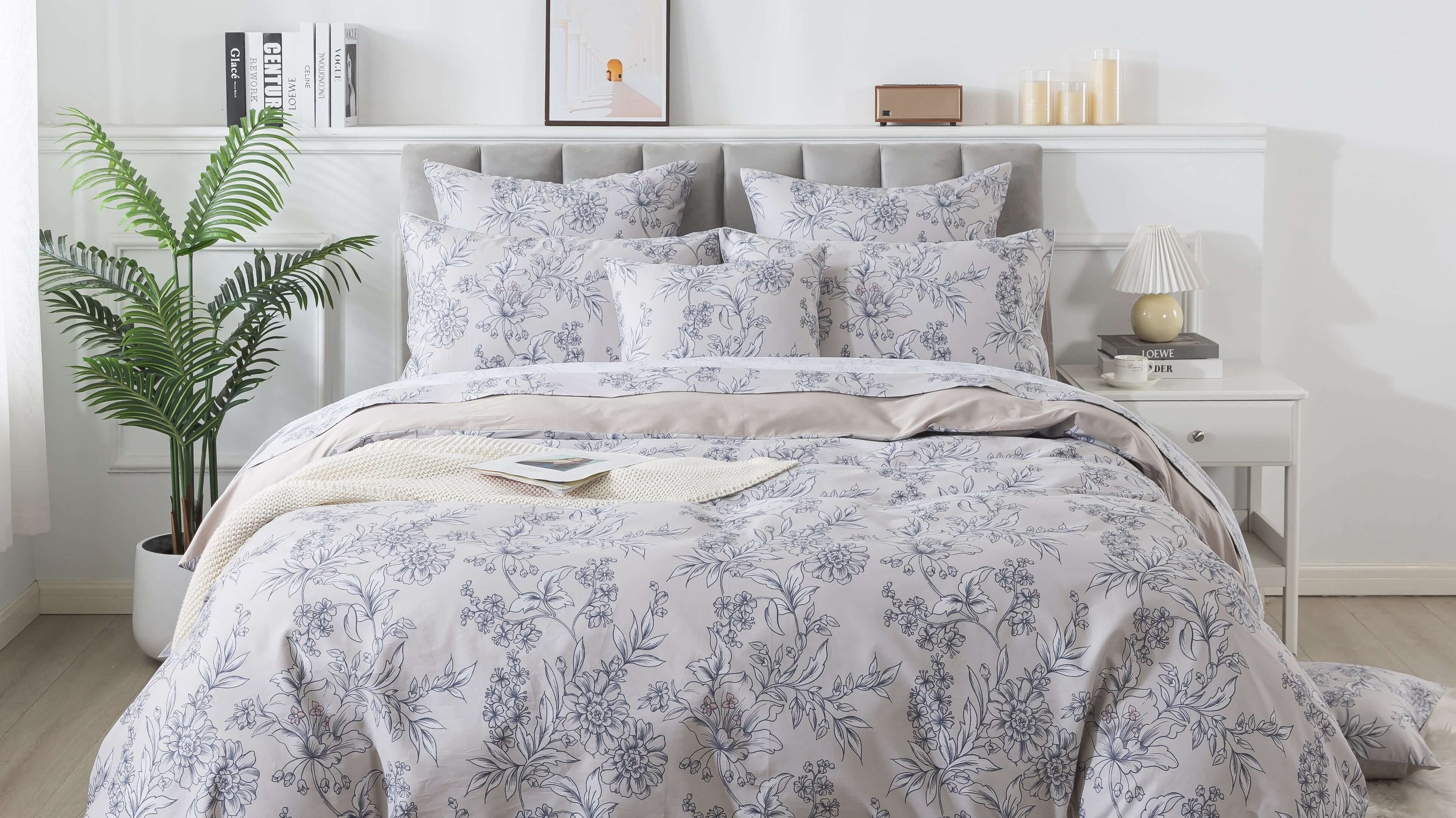 A cozy bedroom with warm bedding on the bed and a floral duvet cover wrapped in a duvet